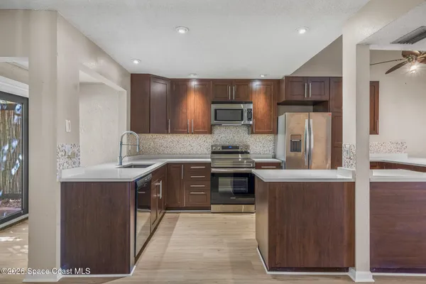 a kitchen with stainless steel appliances granite countertop a stove a refrigerator and a sink