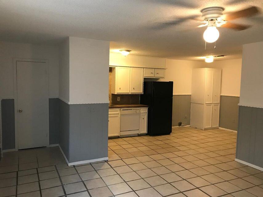 1609 38th Street Lubbock, TX 79412 - Photo 2 of 8 a kitchen with a wooden cabinets and white appliances