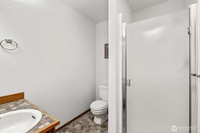 a bathroom with a granite countertop toilet and a sink