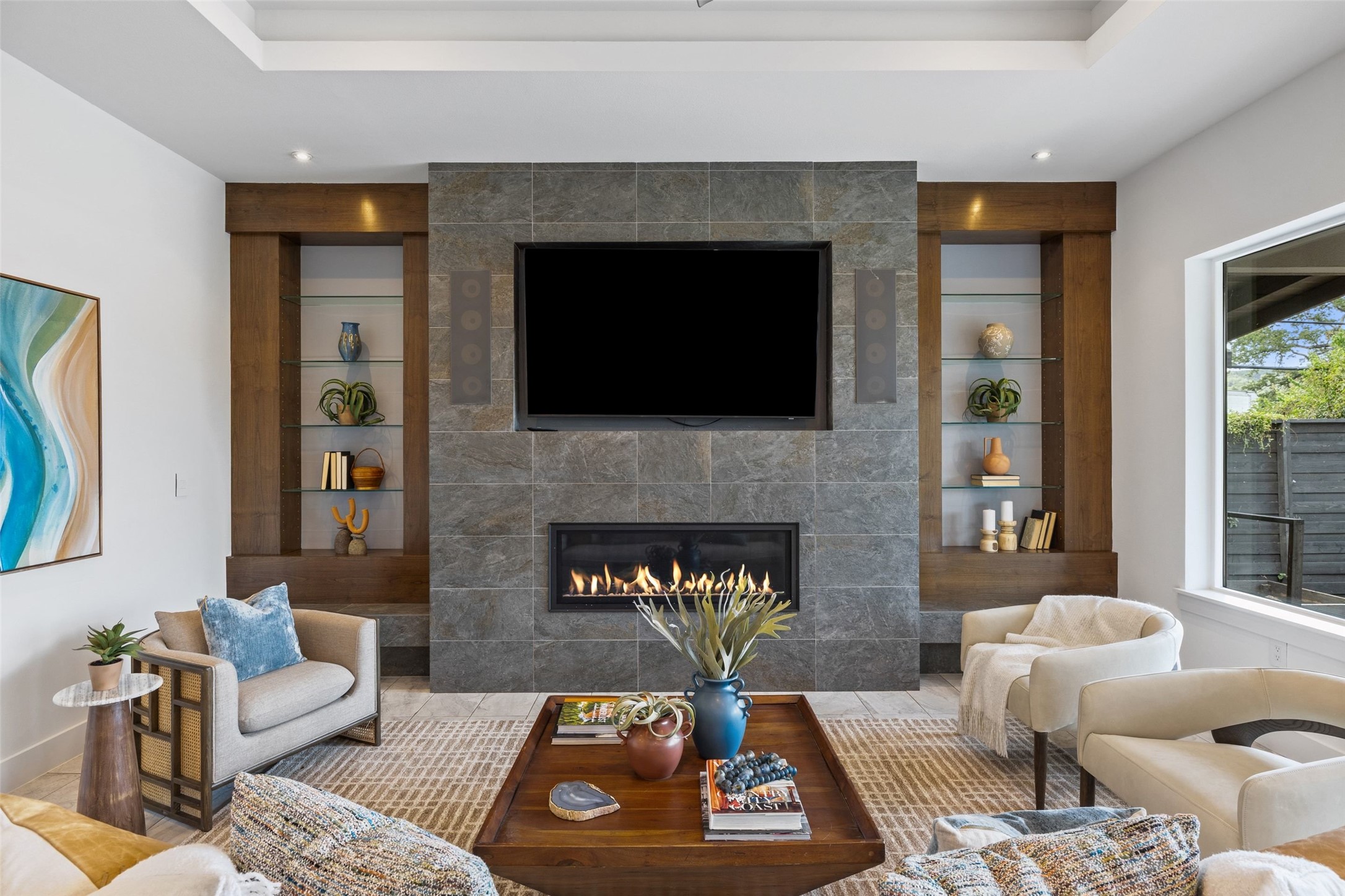 10804 Rush Road, Unit 2 Austin, TX 78732 - Photo 12 of 33 A well-appointed living area features a modern tiled fireplace with an integrated television, flanked by custom built-in shelving.