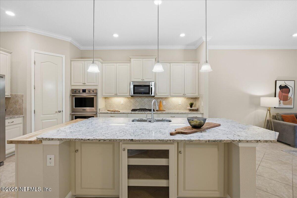 483 St Kitts Loop St. Augustine, FL 32092 - Photo 14 of 52 a kitchen with stainless steel appliances granite countertop a sink a stove and a refrigerator