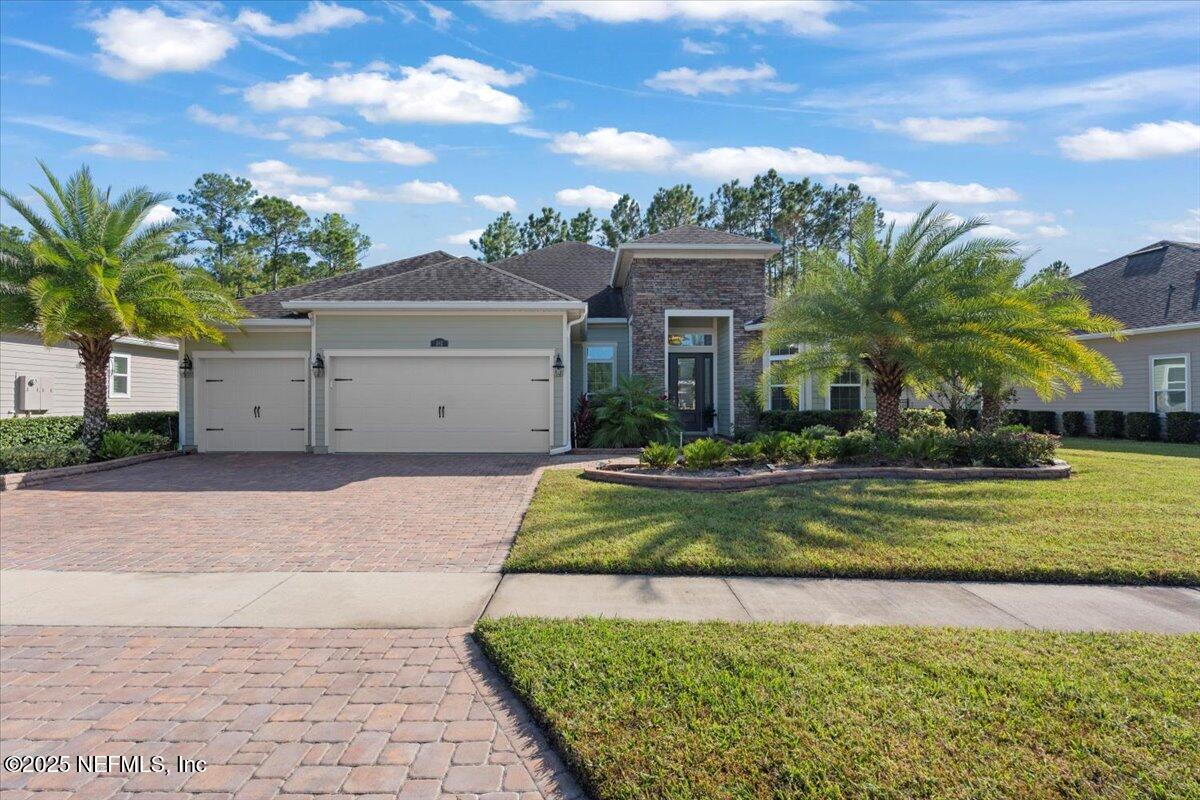 483 St Kitts Loop St. Augustine, FL 32092 - Photo 2 of 52 a front view of a house with a yard garage and outdoor seating