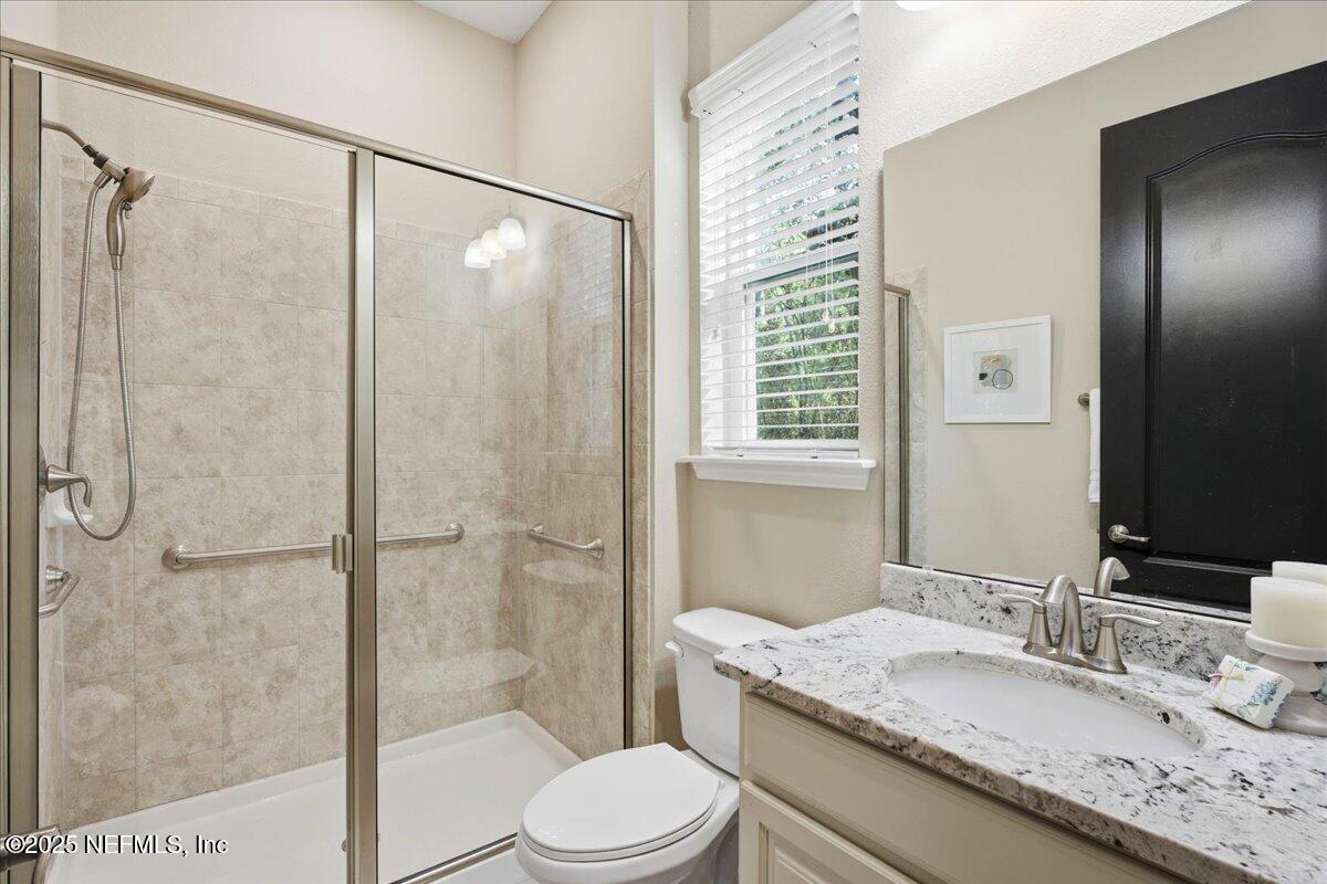 483 St Kitts Loop St. Augustine, FL 32092 - Photo 22 of 52 a bathroom with a granite countertop sink toilet and shower