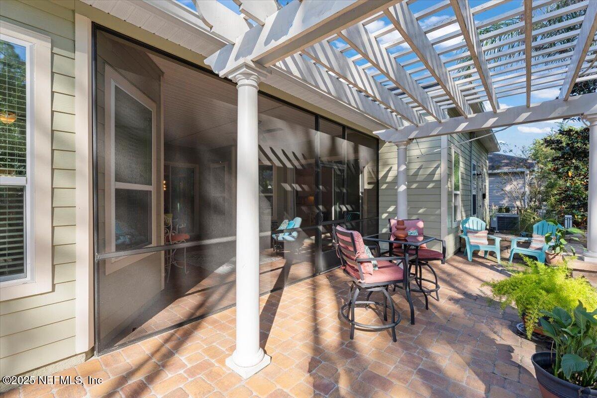 483 St Kitts Loop St. Augustine, FL 32092 - Photo 38 of 52 a view of a patio with table and chairs potted plants and floor to ceiling window