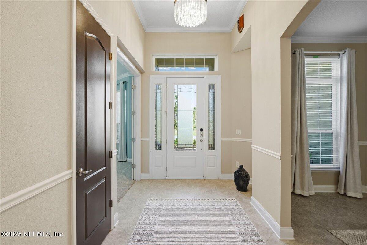 483 St Kitts Loop St. Augustine, FL 32092 - Photo 5 of 52 a view of a hallway with wooden floor and a livingroom with a bathroom