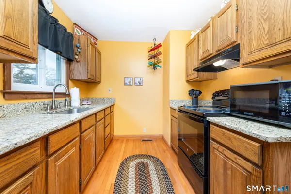 a kitchen with stainless steel appliances granite countertop a sink and a stove