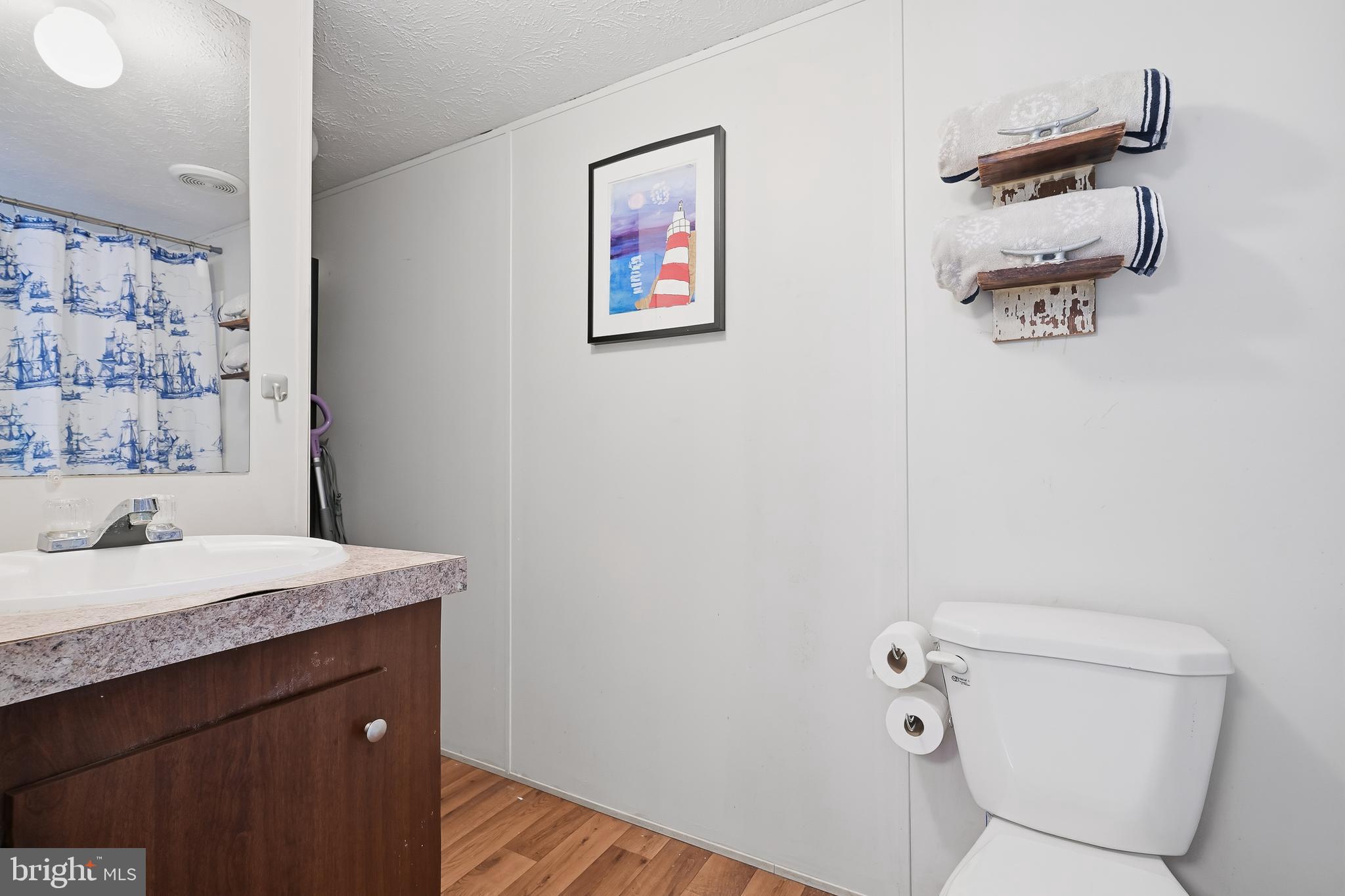 35390 Teal Road, Unit 314 Millsboro, DE 19966 - Photo 12 of 23 a bathroom with a granite countertop sink a toilet and a shower