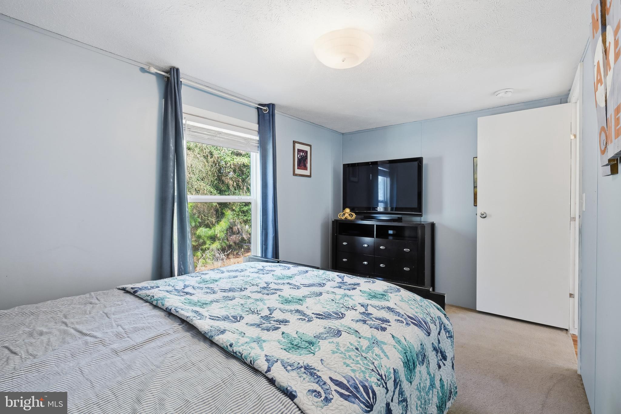 35390 Teal Road, Unit 314 Millsboro, DE 19966 - Photo 16 of 23 a bedroom with a bed and a flat screen tv