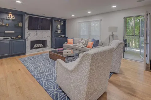 a living room with furniture a fireplace and a large window