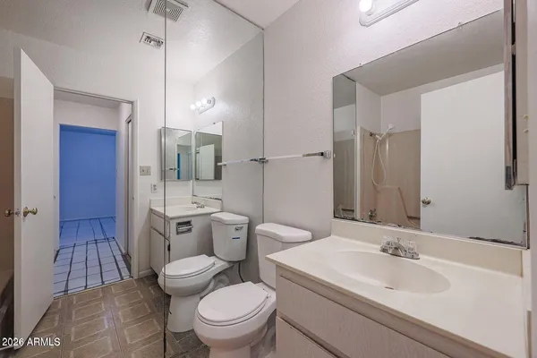 a view of an empty room and chandelier fan