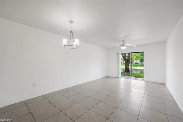 an empty room with windows and chandelier