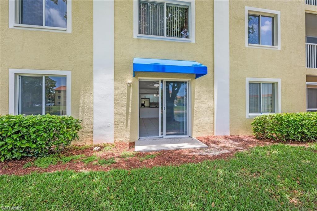 8244 Key Royal Circle, Unit 615 Naples, FL 34119 - Photo 12 of 23 Entrance to property with stucco siding and a lawn