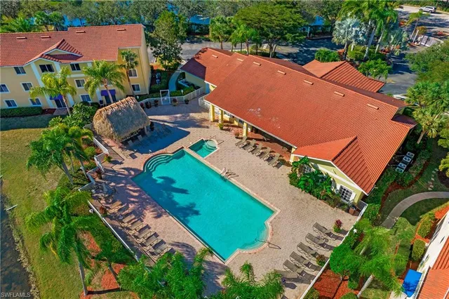 an aerial view of a tennis ground and a cars park side of the road