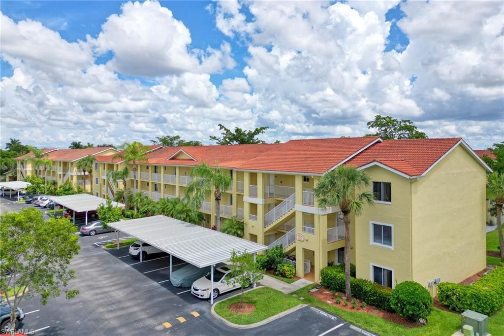 8244 Key Royal Circle, Unit 615 Naples, FL 34119 - Photo 2 of 23 View of apartment building / complex with covered and uncovered parking