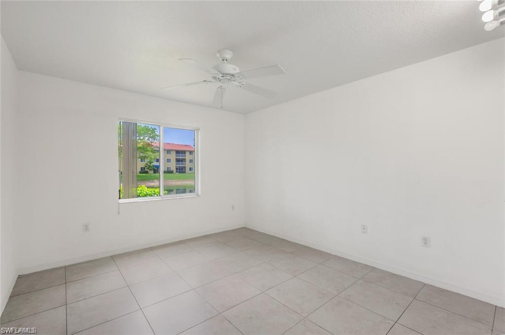 8244 Key Royal Circle, Unit 615 Naples, FL 34119 - Photo 7 of 23 Empty room featuring light tile patterned flooring and ceiling fan