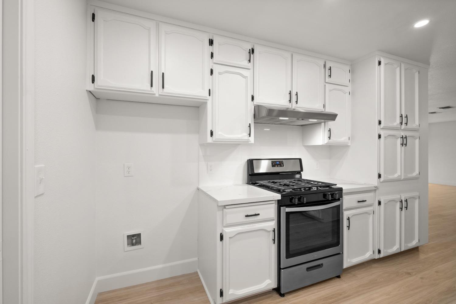 42906 Ranger Cir Drive Coarsegold, CA 93614 - Photo 11 of 29 a kitchen with stainless steel appliances granite countertop white cabinets and a stove a oven with wooden floor