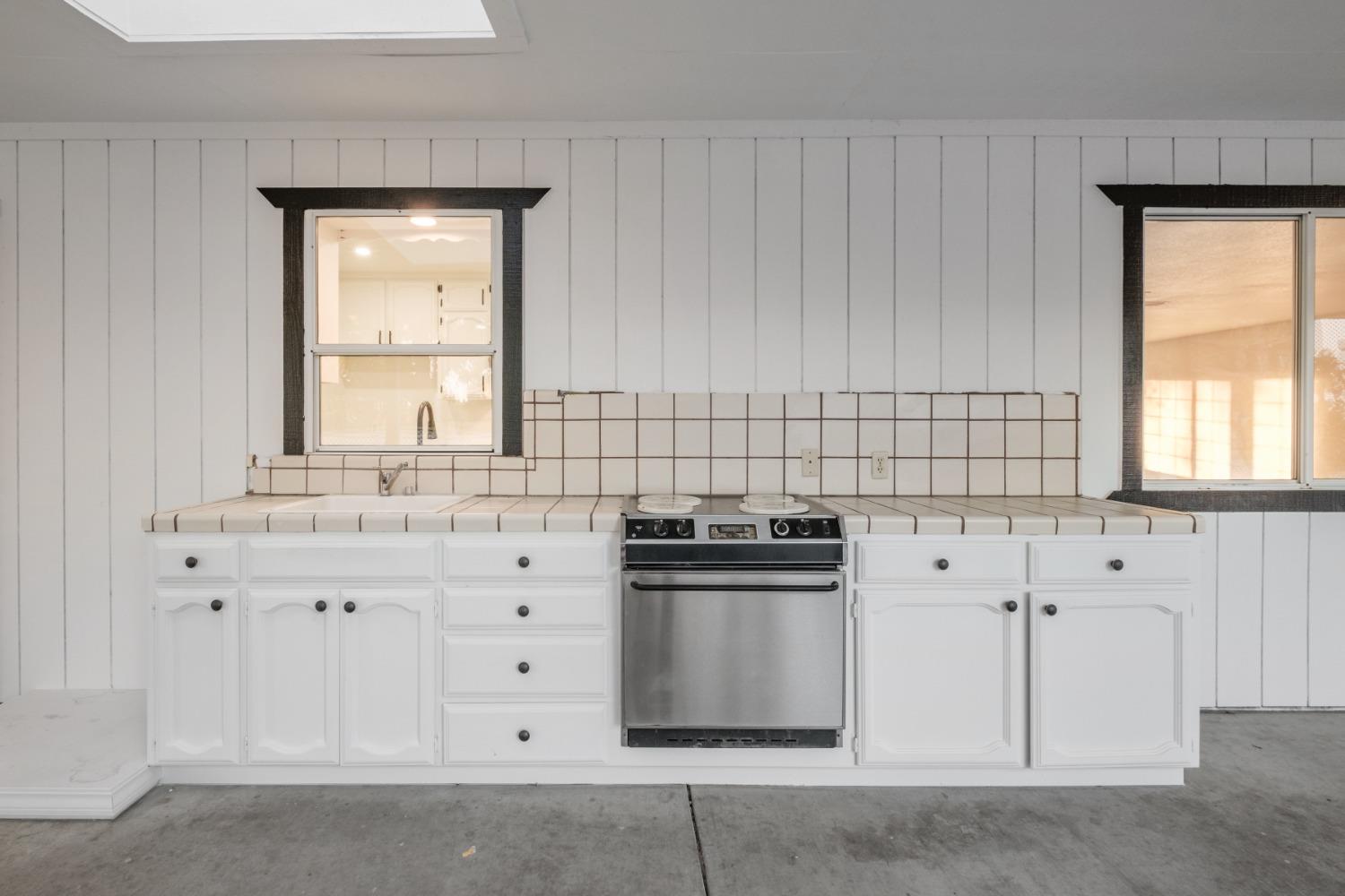 42906 Ranger Cir Drive Coarsegold, CA 93614 - Photo 21 of 29 a kitchen with granite countertop white cabinets and window