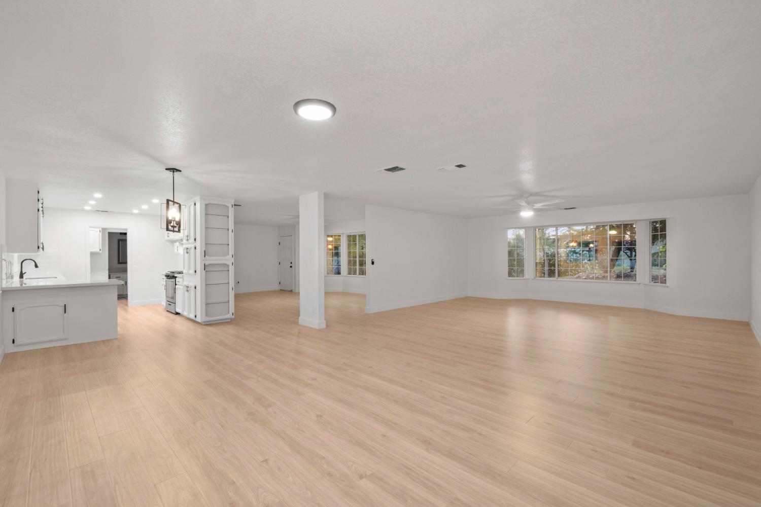 42906 Ranger Cir Drive Coarsegold, CA 93614 - Photo 8 of 29 a view of an empty room with wooden floor and a kitchen