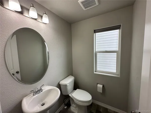 a bathroom with a toilet a sink and mirror