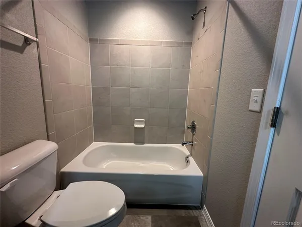 a white toilet sitting next to a bath tub