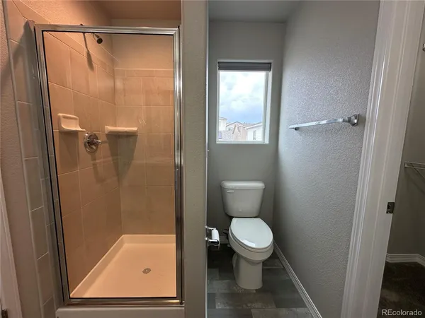 a bathroom with a toilet and a shower