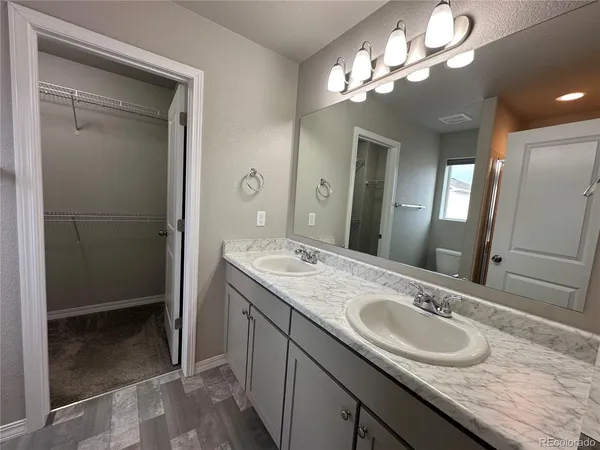 a bathroom with a granite countertop sink a large mirror and a shower