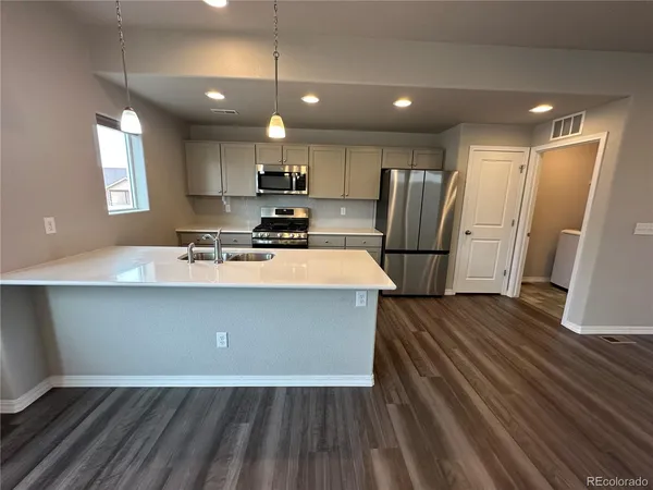 a kitchen with kitchen island a sink appliances and cabinets