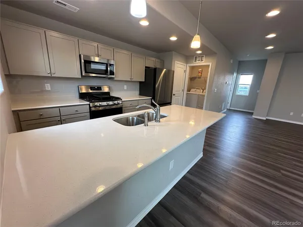 a kitchen with stainless steel appliances a refrigerator sink and microwave