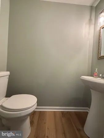 a white toilet sitting next to a white sink and vanity