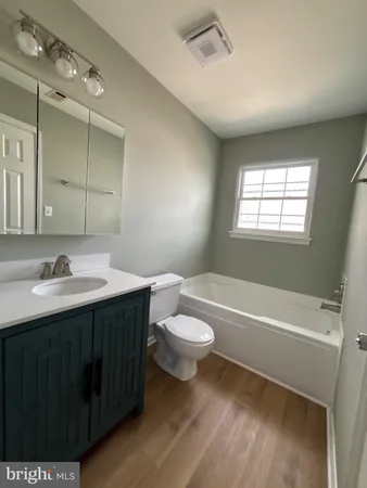 a bathroom with a sink a toilet a mirror and shower