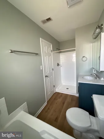 a bathroom with a sink a toilet a mirror and shower