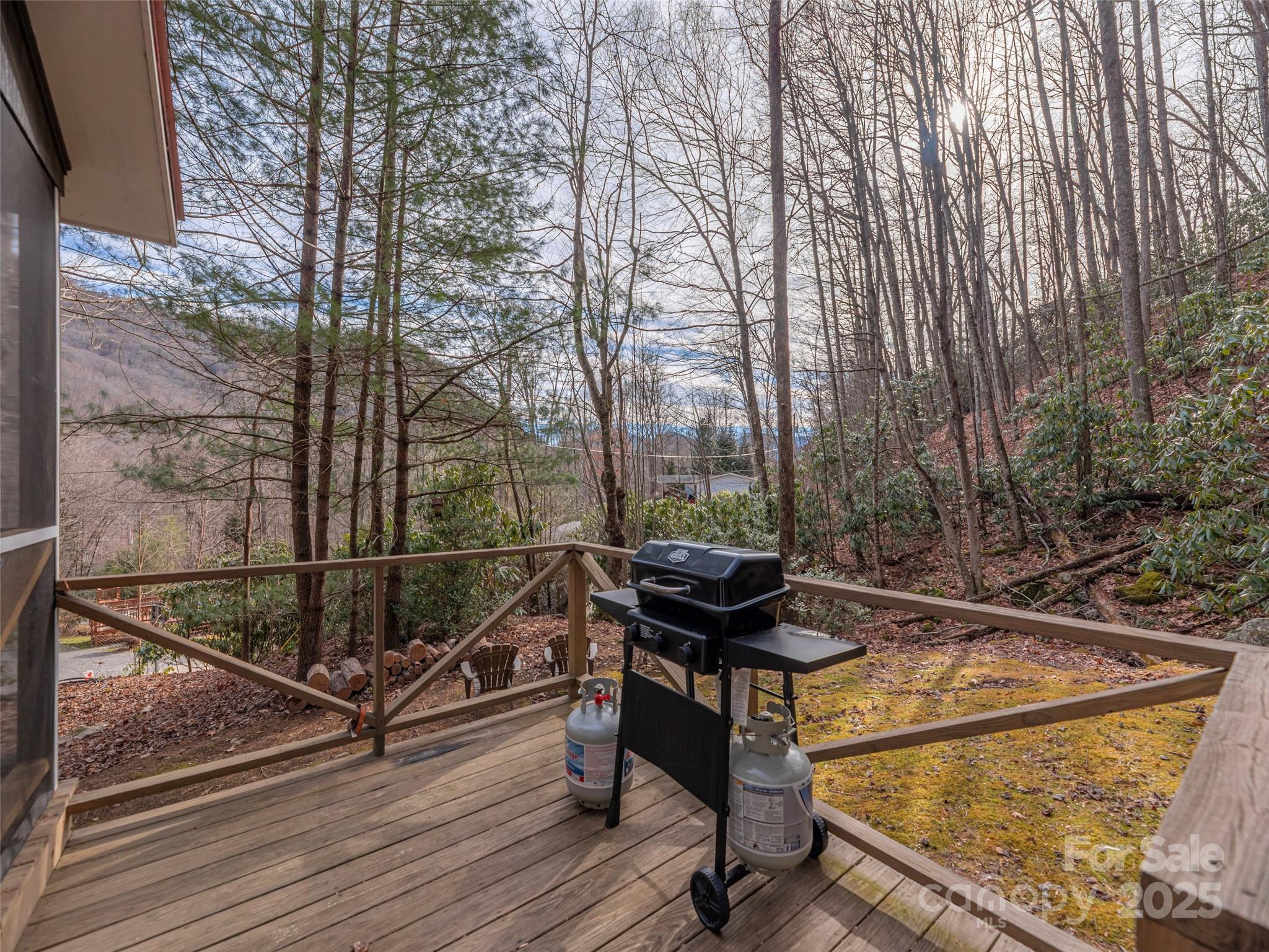 155 Mull Cove Road Maggie Valley, NC 28751 - Photo 15 of 19 a view of a balcony with chairs and wooden floor