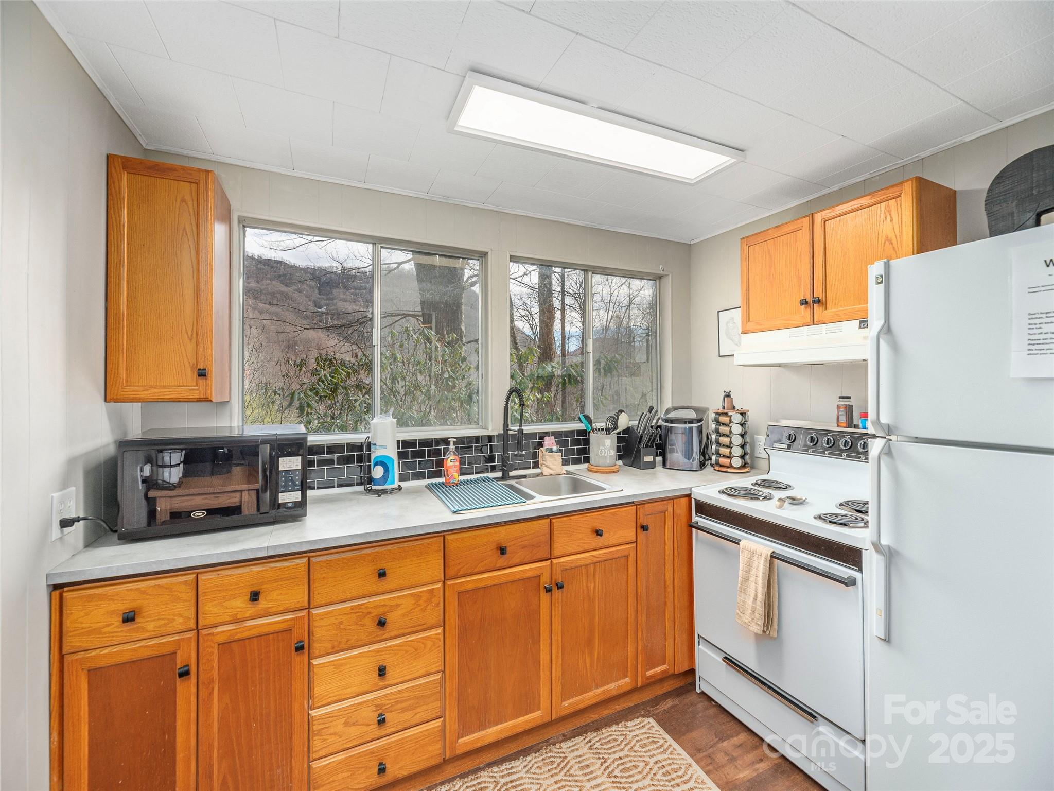 155 Mull Cove Road Maggie Valley, NC 28751 - Photo 6 of 19 a kitchen with a sink window and cabinets