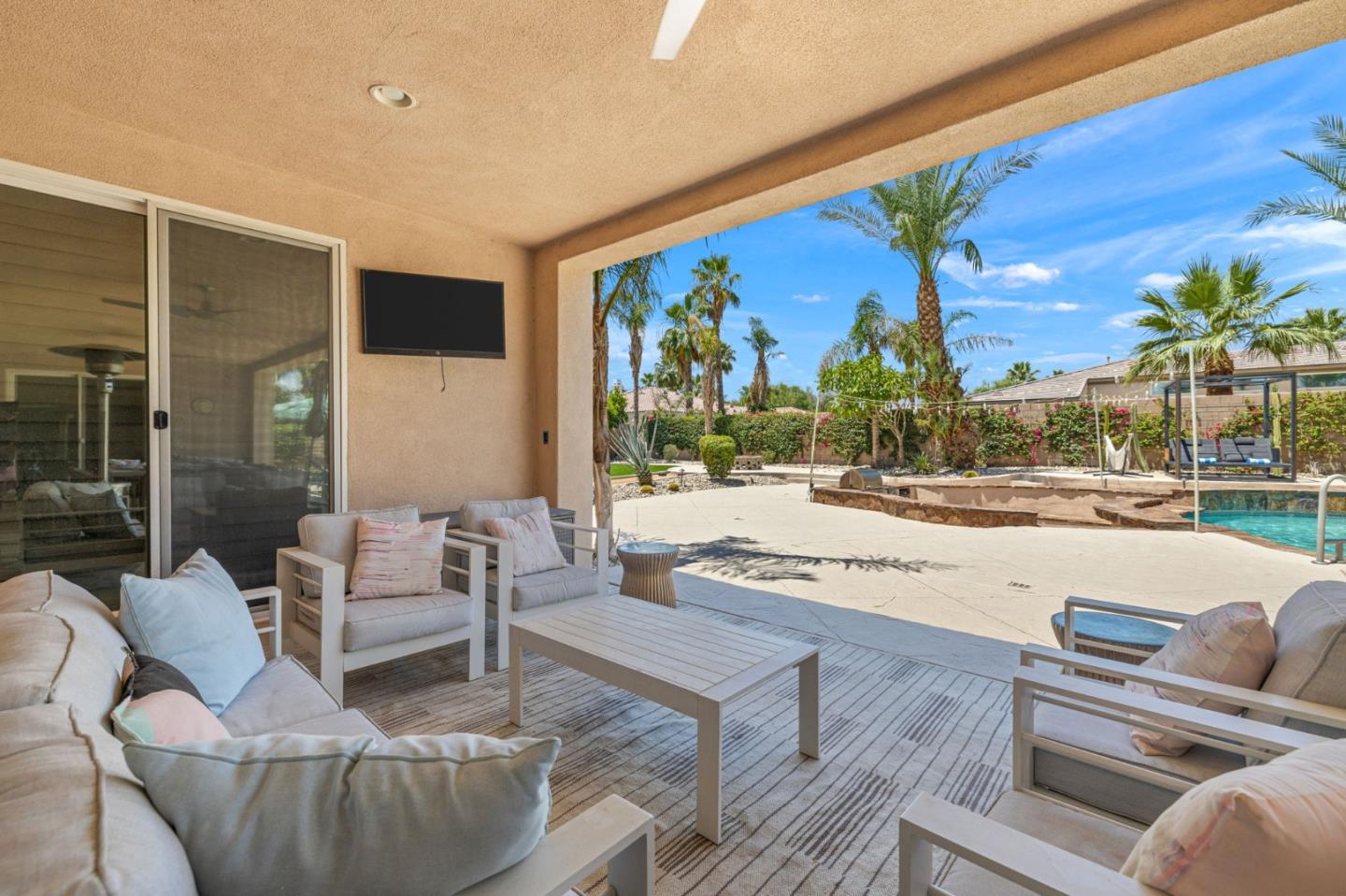 49133 Jordan Street Indio, CA 92201 - Photo 60 of 60 a living room with couches painting on the wall and a floor to ceiling window