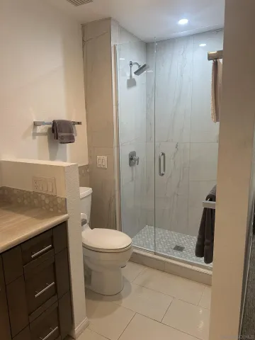 a bathroom with a shower a toilet and a sink
