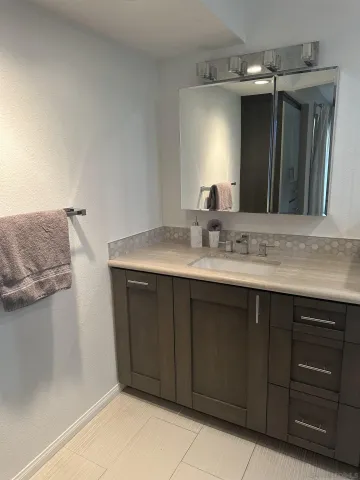 a bathroom with a granite countertop sink and a mirror