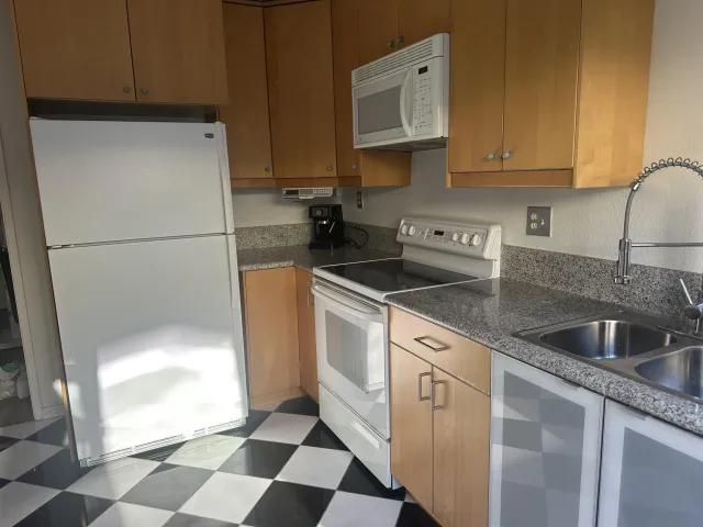 a kitchen with a sink a refrigerator and cabinets