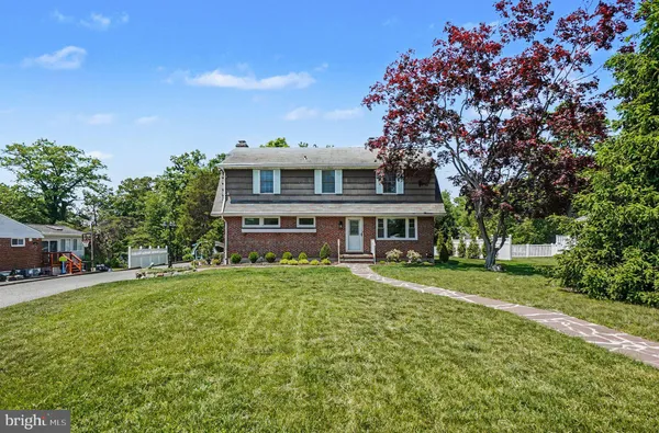 a view of a house with a big yard and large trees