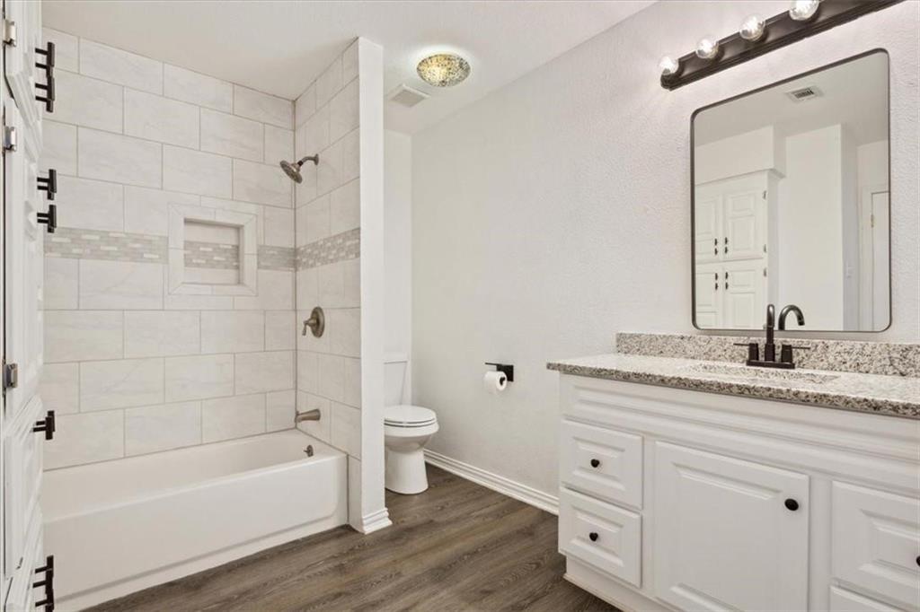 2306 Melissa Drive Waco, TX 76708 - Photo 14 of 22 a bathroom with a granite countertop sink a toilet and shower