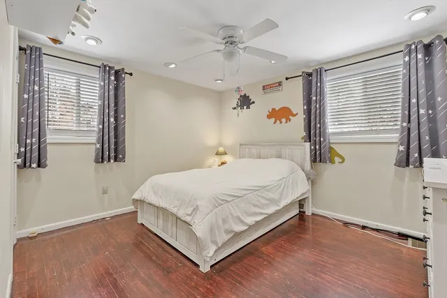 a bedroom with a bed and wooden floor