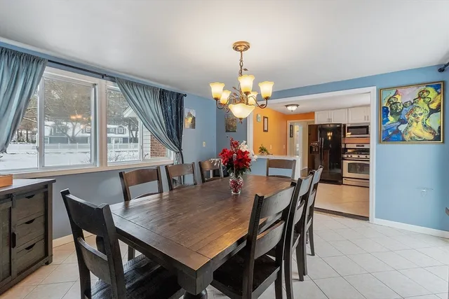 a view of a dining room with furniture a livingroom and chandelier