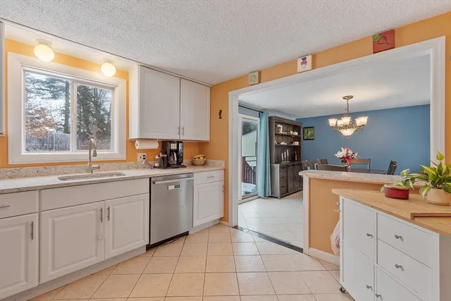 a kitchen with granite countertop white cabinets and white appliances