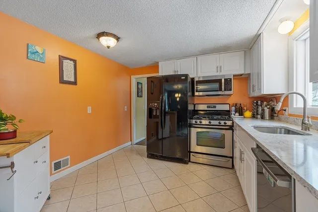 a kitchen with stainless steel appliances granite countertop a refrigerator and a sink