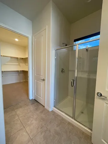 a bathroom with a shower and a glass door