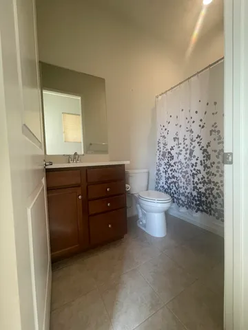 a bathroom with a granite countertop sink toilet and a mirror