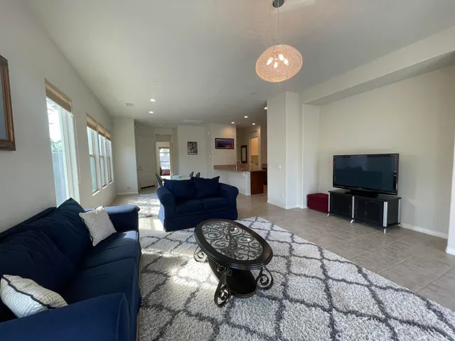 a living room with furniture a flat screen tv and a table