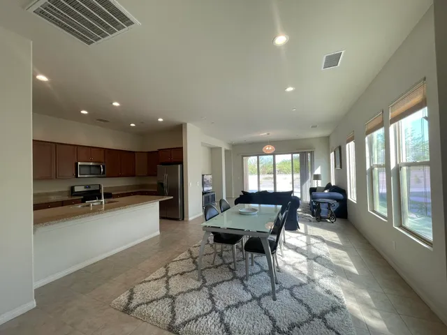 a living room with stainless steel appliances furniture and a large window