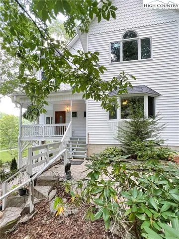 a view of a house with a yard and tree s