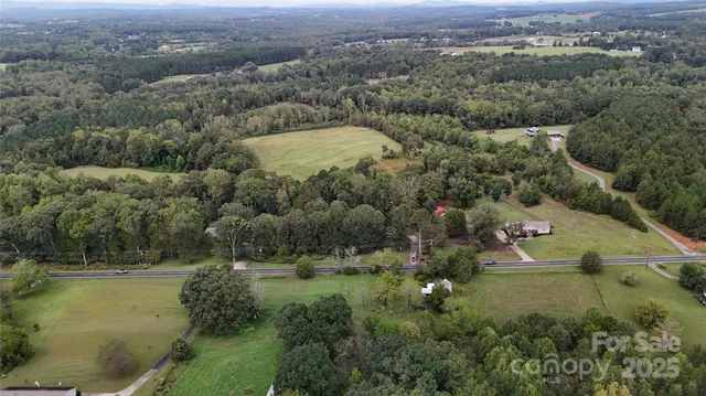 an aerial view of residential houses with outdoor space and trees