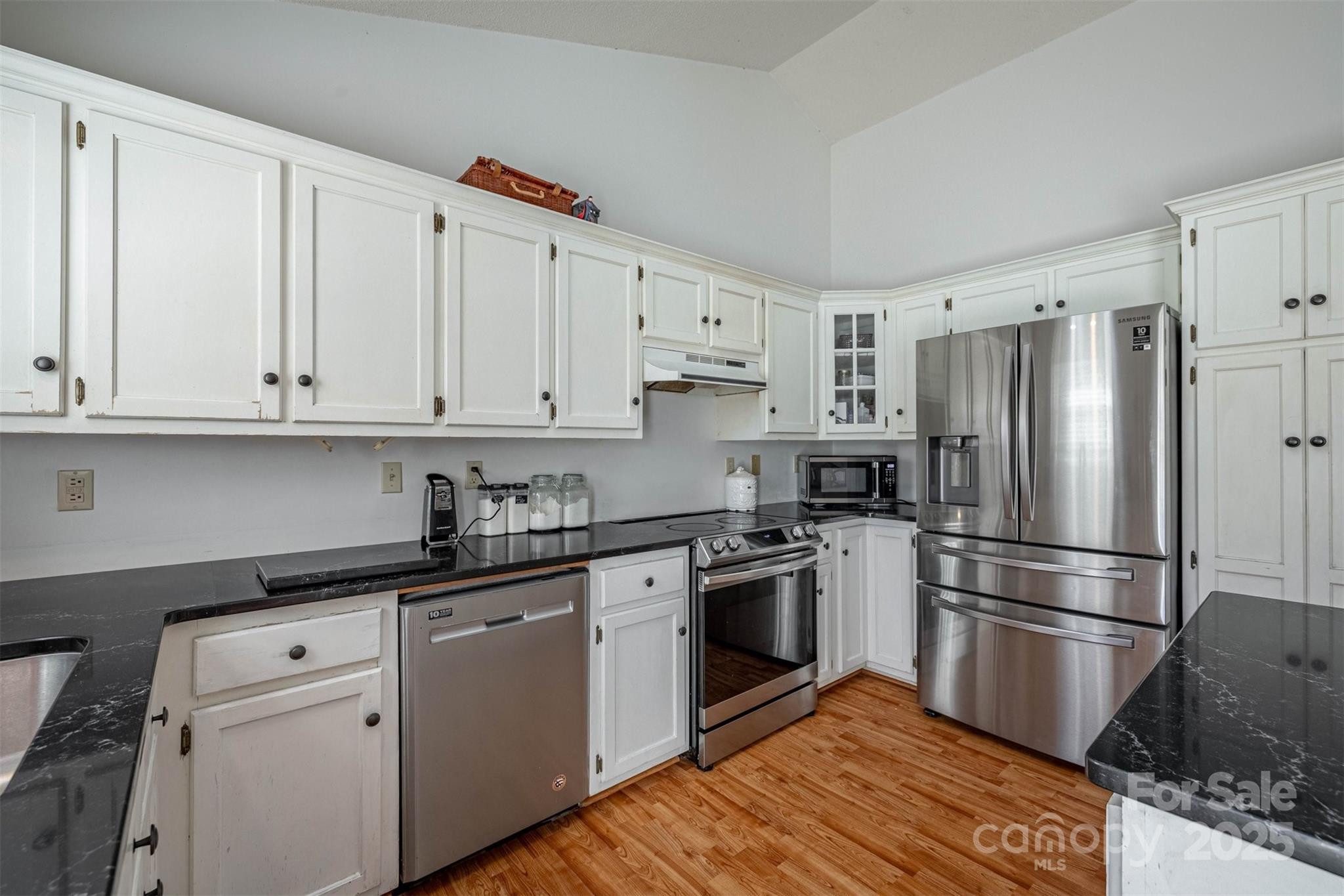 2693 Farmland Acrs Road Morganton, NC 28655 - Photo 21 of 33 a kitchen with cabinets stainless steel appliances and wooden floor